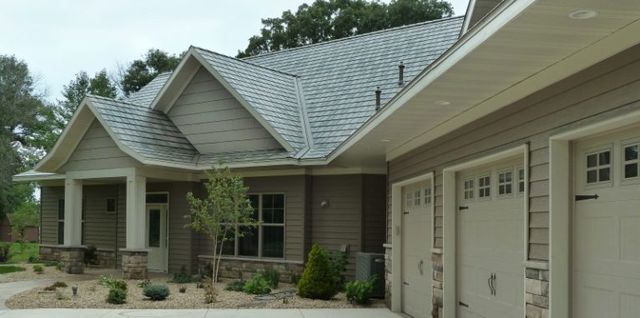 Ranch home with a metal roof, tan siding and stone accents